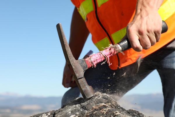 Student hammering a rock